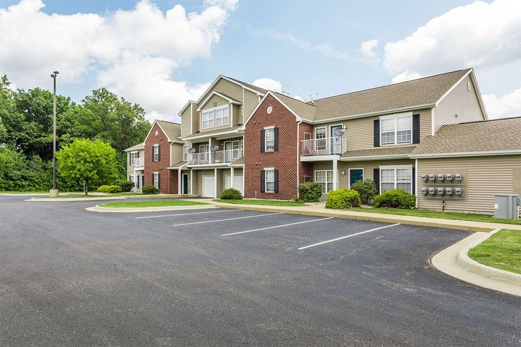 an empty parking lot in front of a row of houses