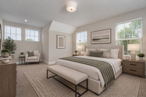 A bedroom with a large bed and a chair.