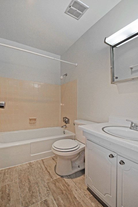 a bathroom with a toilet and a tub and a sink