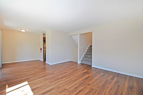 a living room with a hard wood floor and a staircase