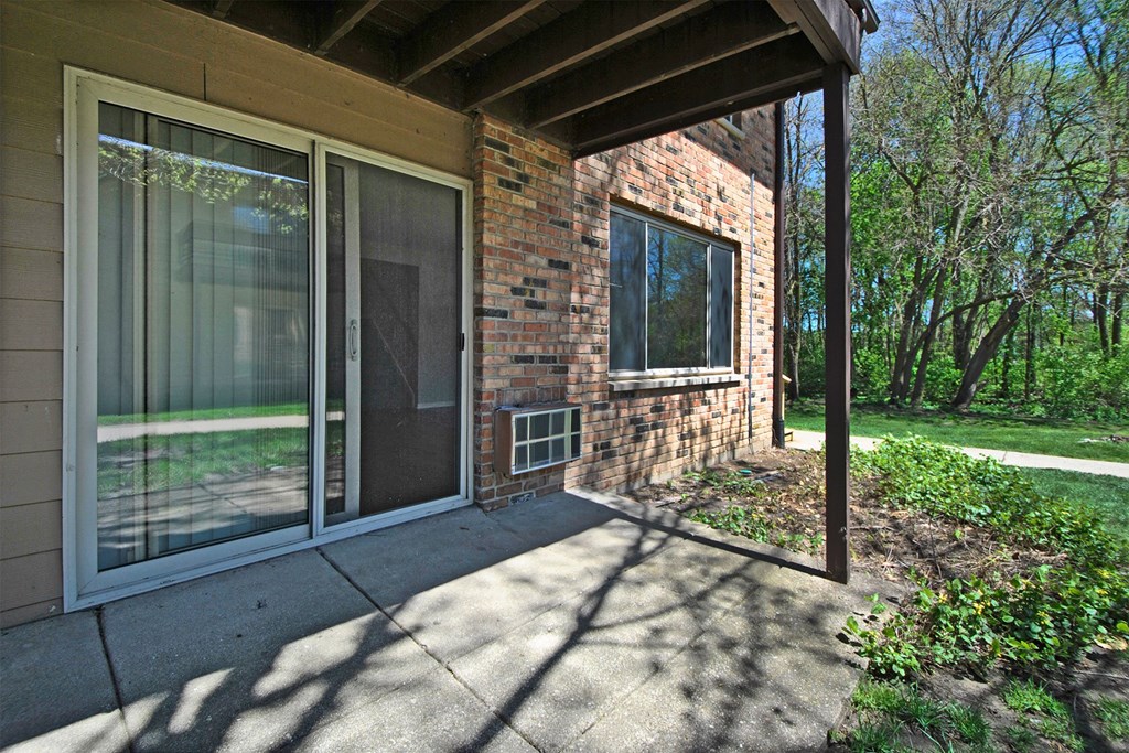 the front porch of a brick house with sliding glass doors