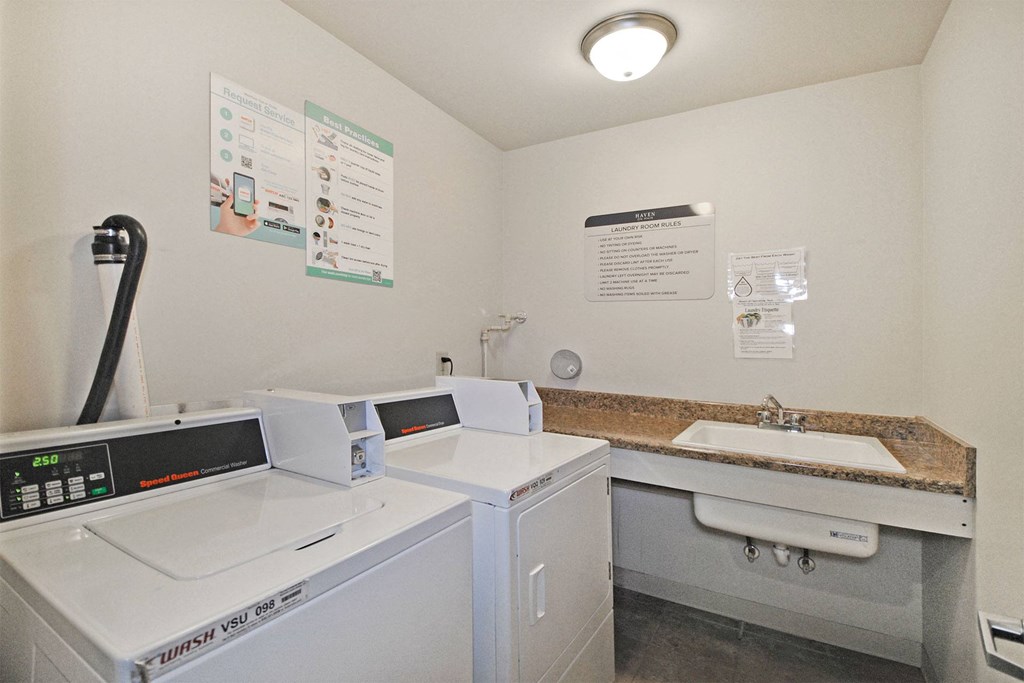 a laundry room with two washing machines and a sink