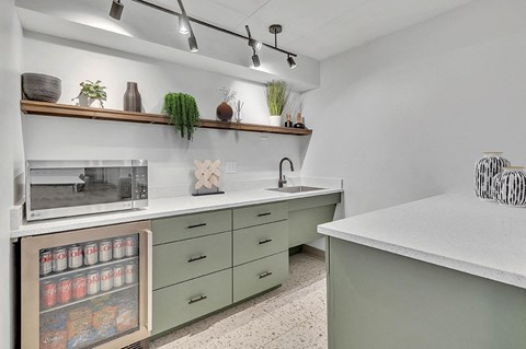 a kitchen with green cabinets and a counter top and a microwave