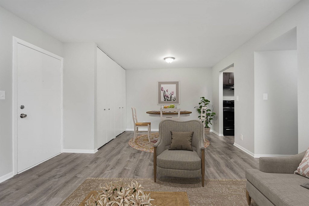 a living room and dining room with white walls and wood floors