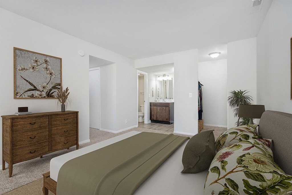 a bedroom with a bed and a dresser and a bathroom