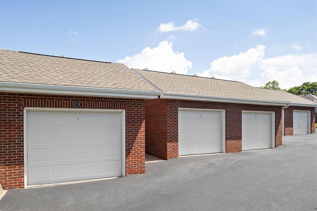 the front of a brick building with two garage doors