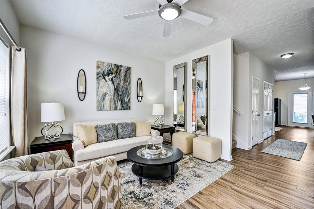 a living room with furniture and a ceiling fan