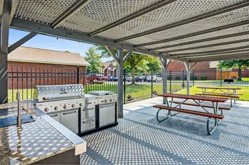 a patio with a picnic table and stainless steel appliances