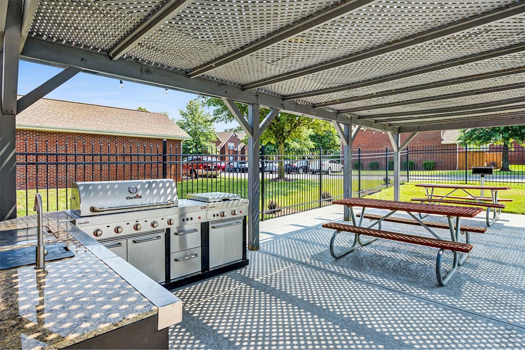 a patio with a picnic table and stainless steel appliances