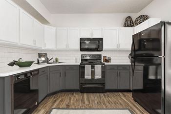 a kitchen with black appliances and white cabinets