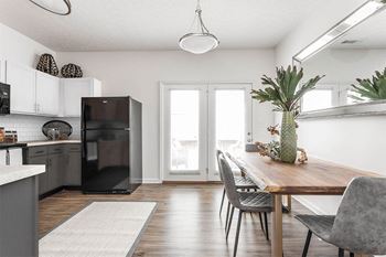 a kitchen and dining room with a refrigerator and a table