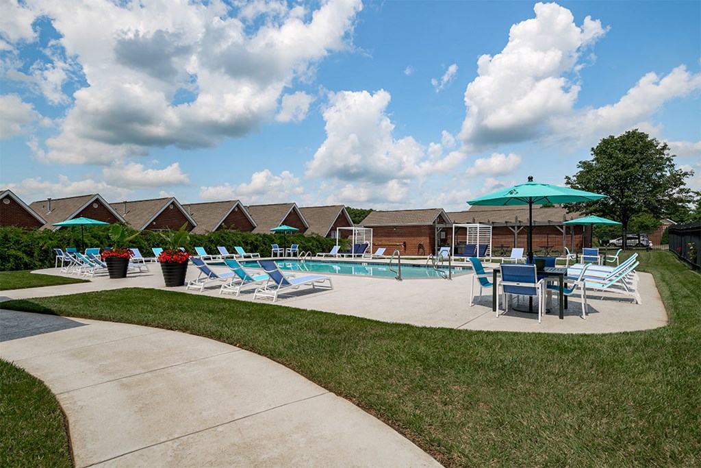 our apartments have a pool and patio with chairs and umbrellas