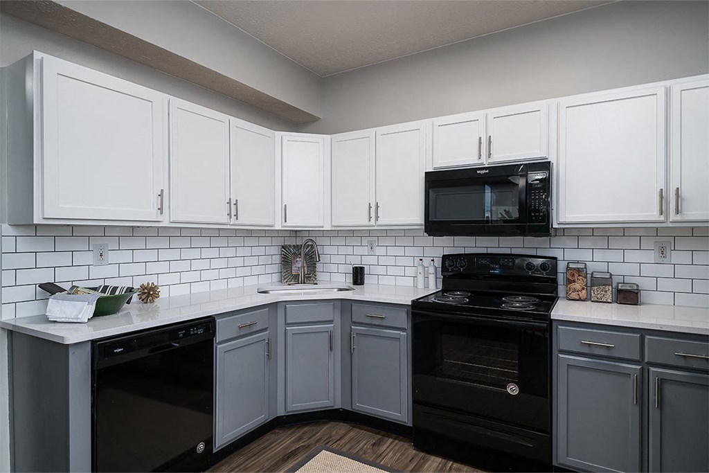 a kitchen with black appliances and white cabinets