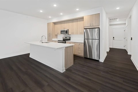 A modern kitchen with a white countertop and stainless steel appliances.