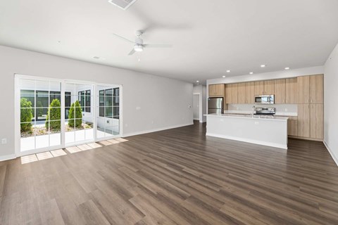 A spacious room with wooden flooring and a ceiling fan.