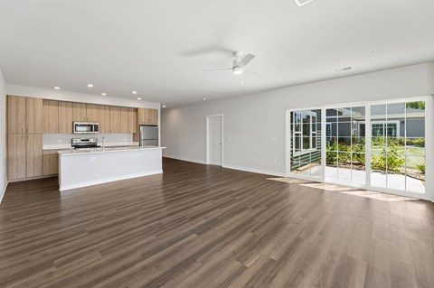 A modern kitchen with wooden floors and white appliances.
