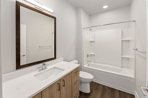 A white bathroom with a toilet, sink, and bathtub.