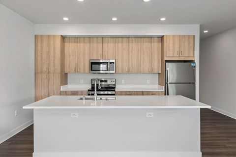 A modern kitchen with wooden cabinets and stainless steel appliances.