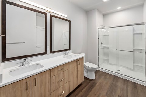 A bathroom with a toilet, sink, and mirrors.
