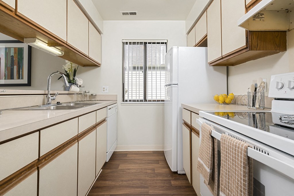 a kitchen with white cabinets and a sink and a refrigerator