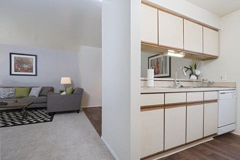 a kitchen with white cabinets and a living room with a couch