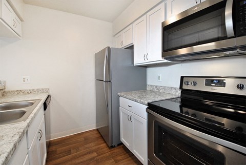 a kitchen with stainless steel appliances and white cabinets