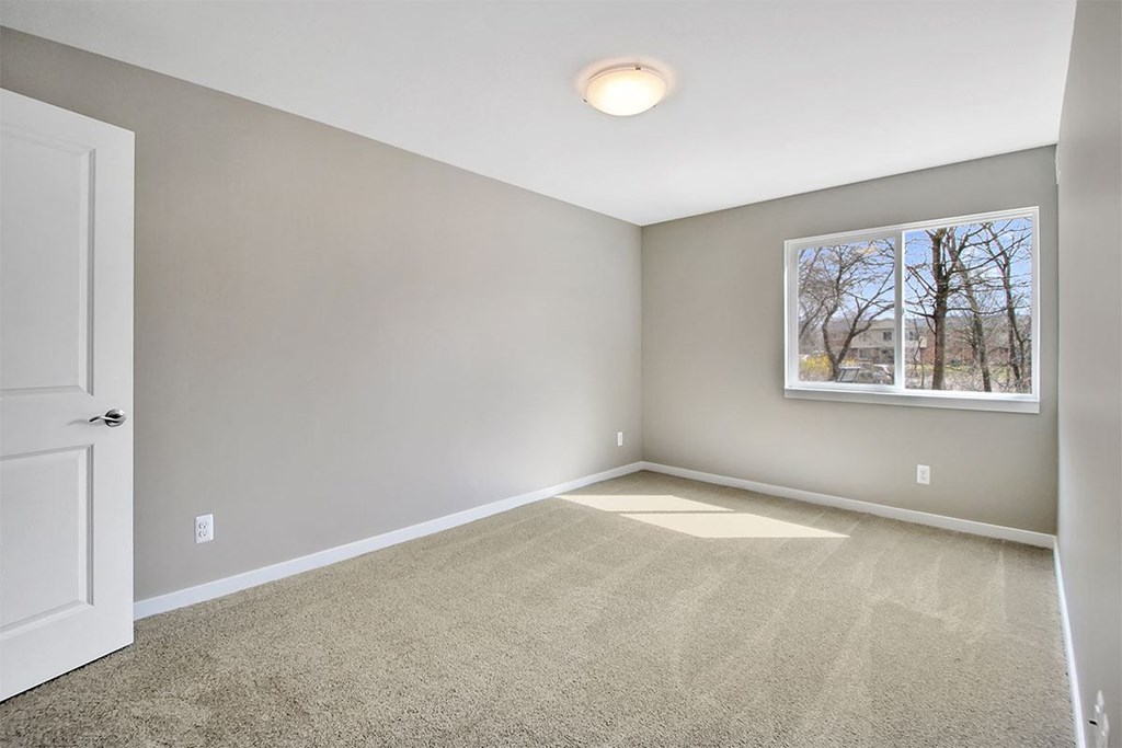 an empty room with carpet and a window