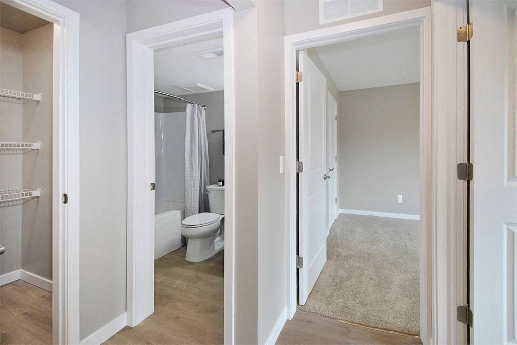 a bedroom with a toilet and a hallway to a bathroom