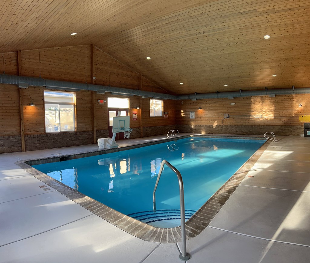 A large indoor swimming pool with a diving board.