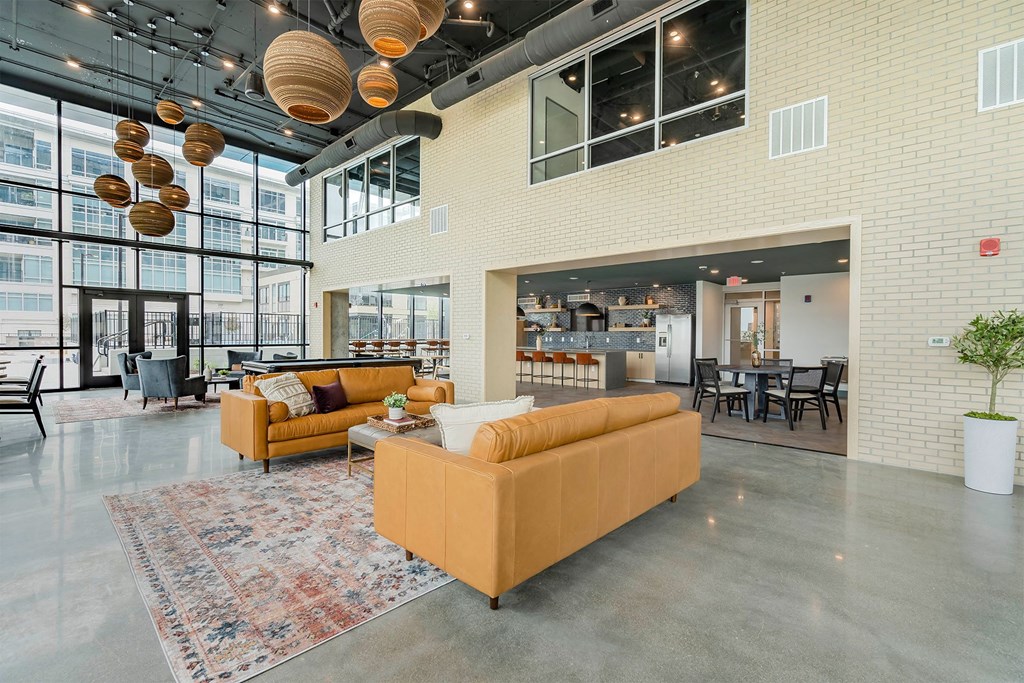 a large lobby with couches and chairs in a building with large windows