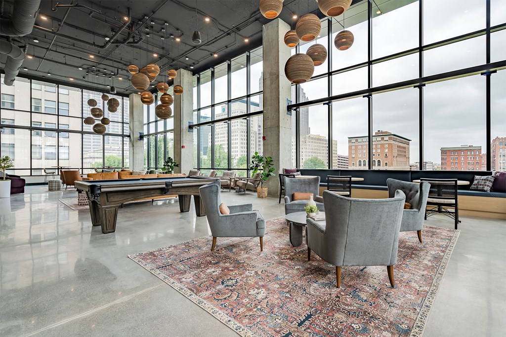 a lounge area with a pool table and large windows