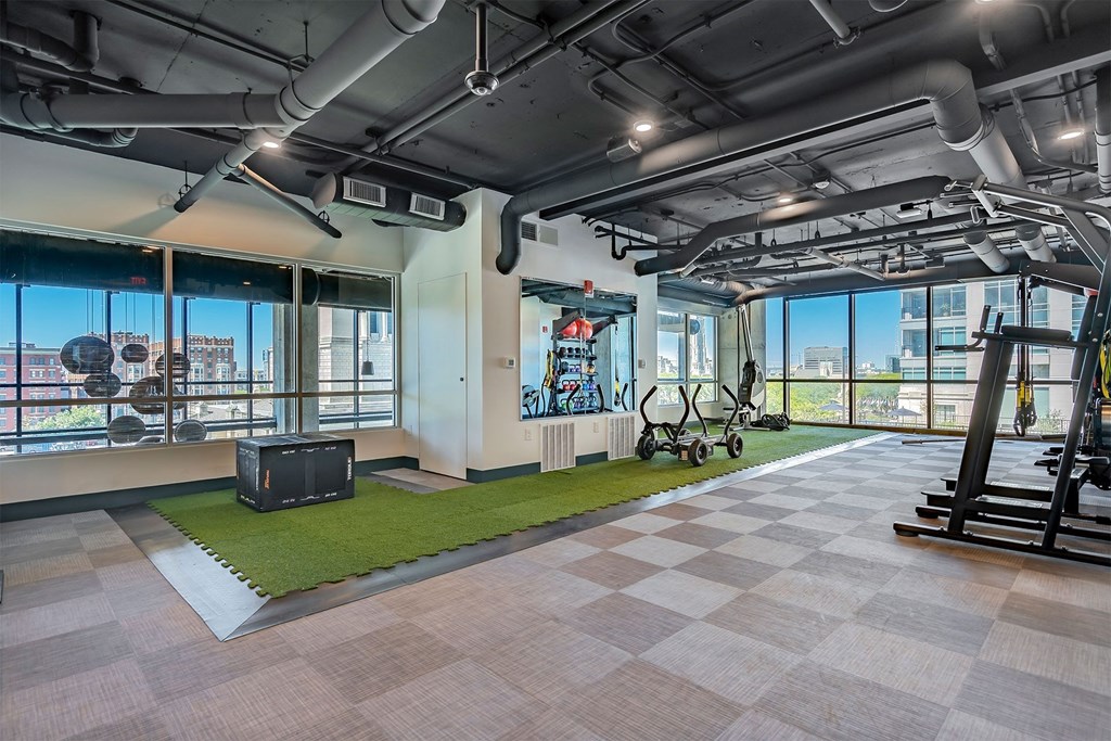 a workout room with a view of the city and a large window