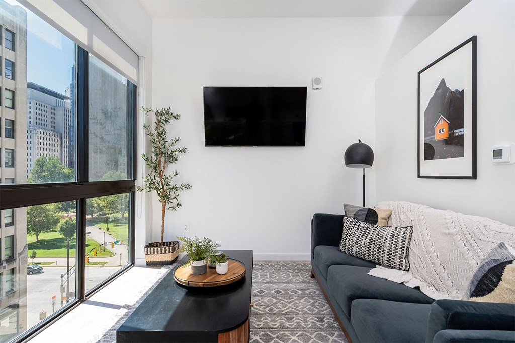 a living room with a black couch and a large window