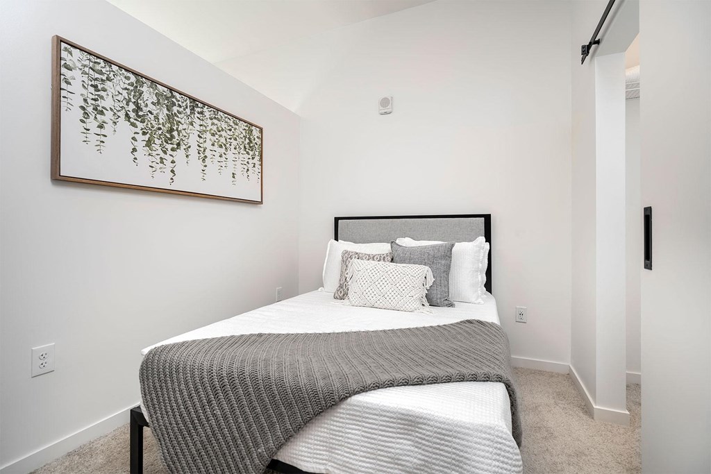 a bedroom with a bed and a painting on the wall