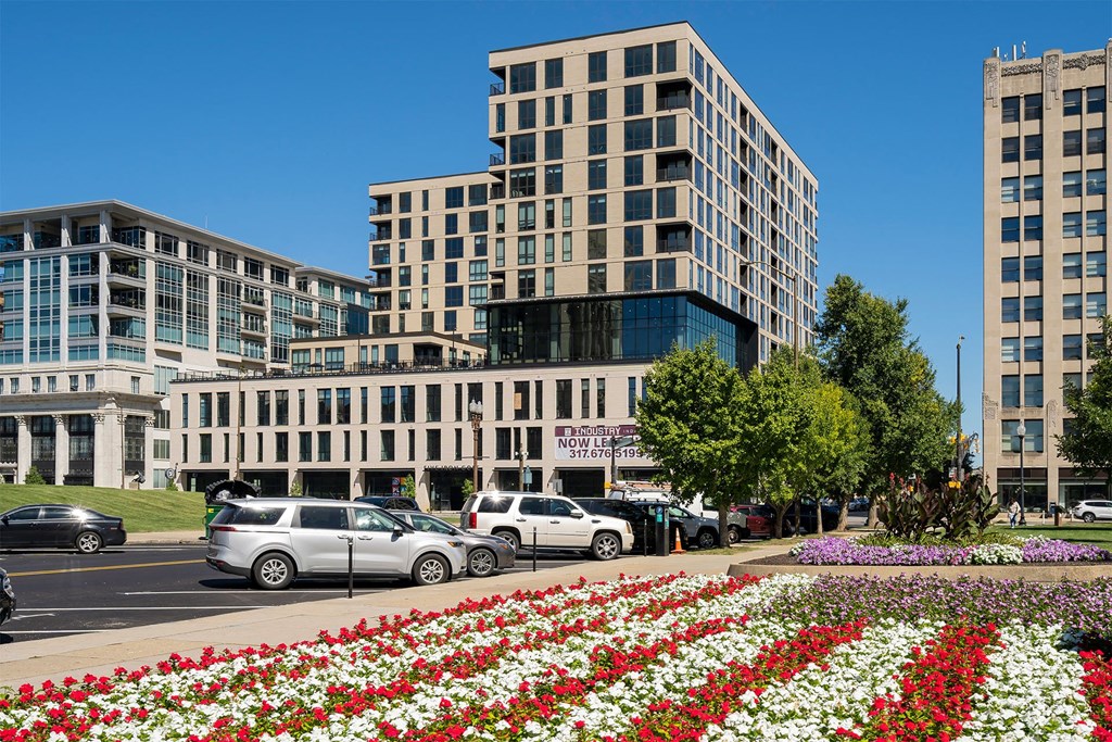 a view of a city street with buildings and flowers