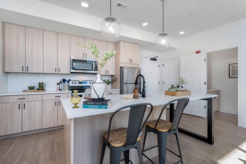 an open kitchen with a large island with two chairs