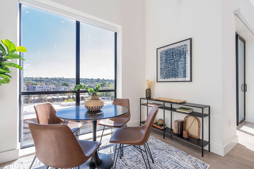 a dining room with a large window and a table with chairs