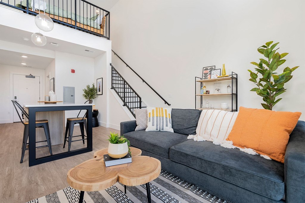 a living room with a couch and a table and a staircase