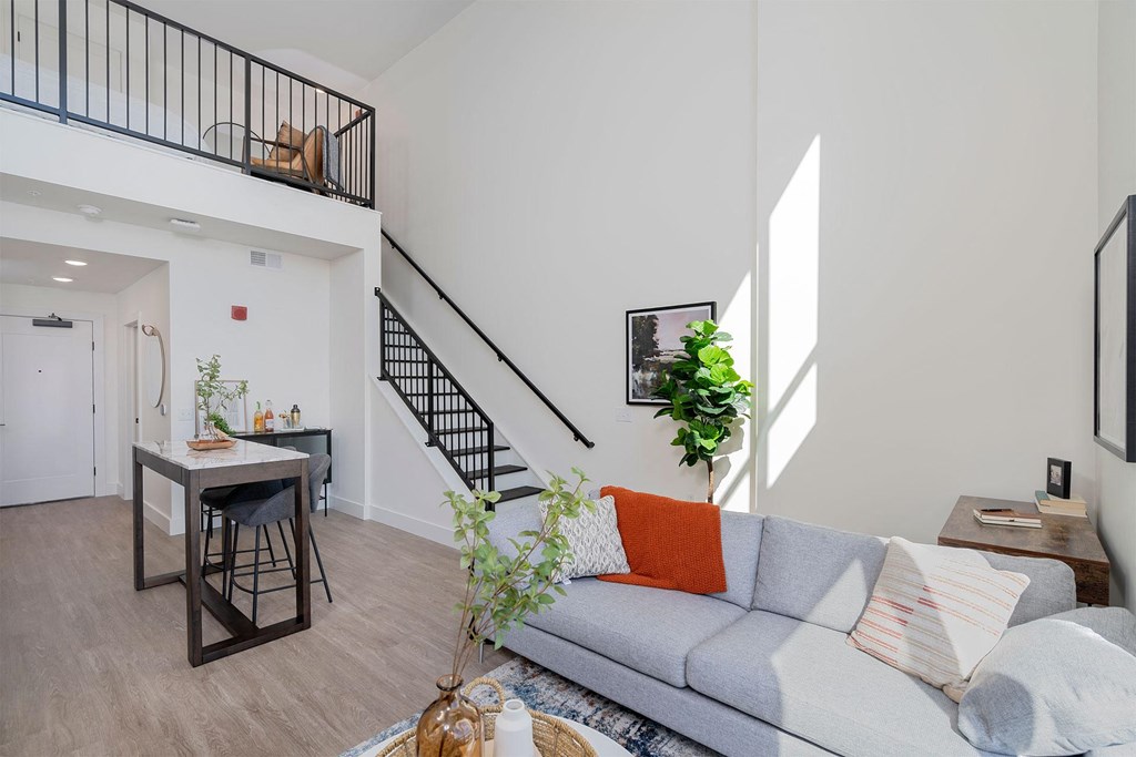 a living room with a couch and a table and a staircase