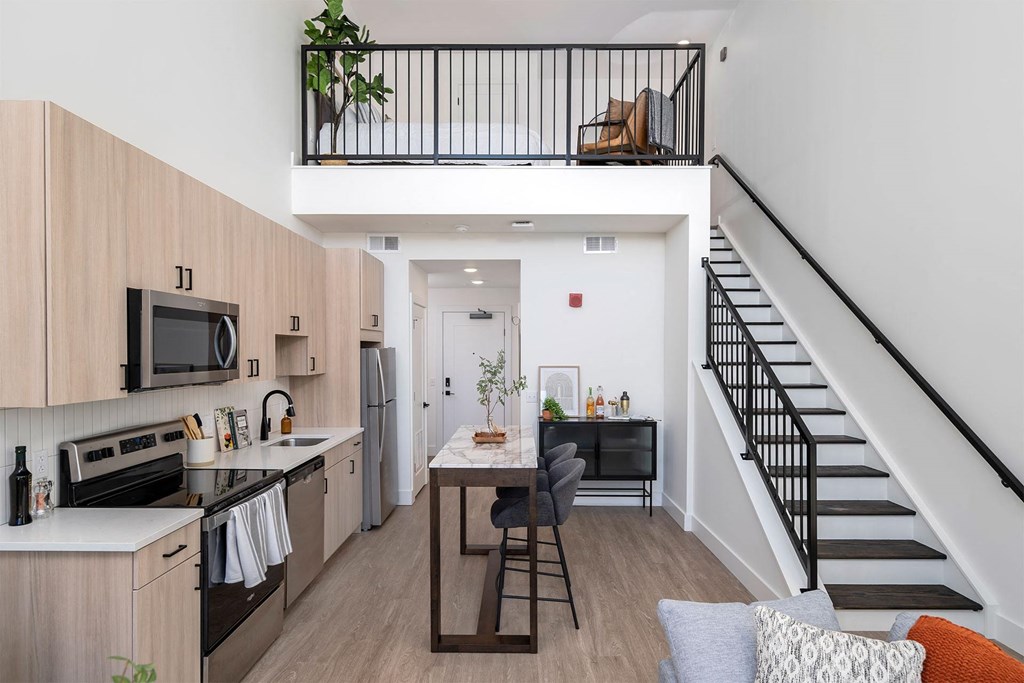 a living room with a kitchen and a staircase