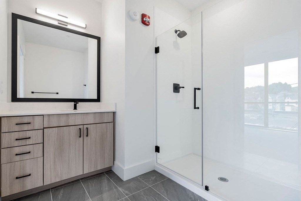 a bathroom with a shower and a sink and a mirror