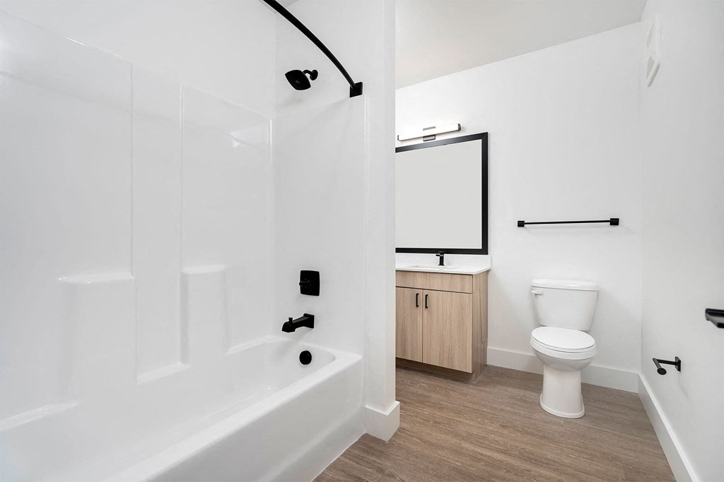 a bathroom with a toilet and a tub and a sink