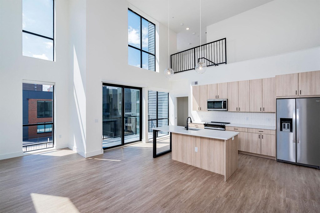 a kitchen with a large island and a stainless steel refrigerator