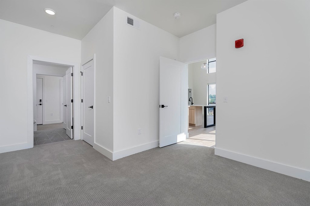 a living room with white walls and a gray carpet