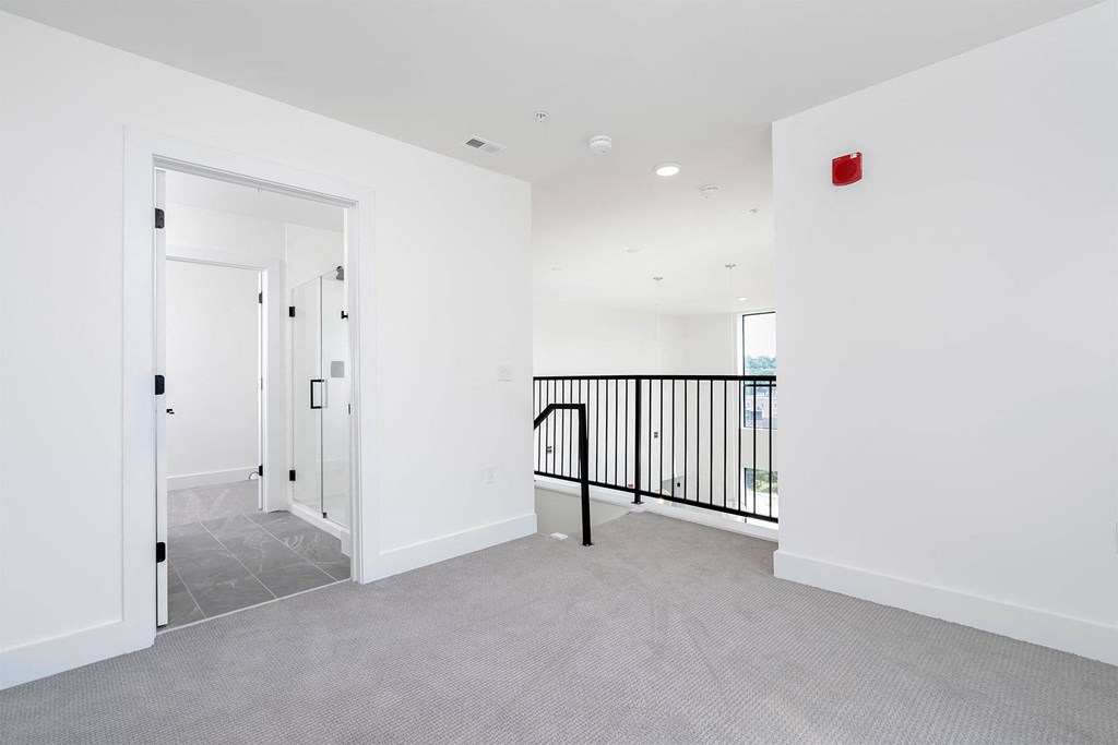 a white room with a balcony and a stairwell