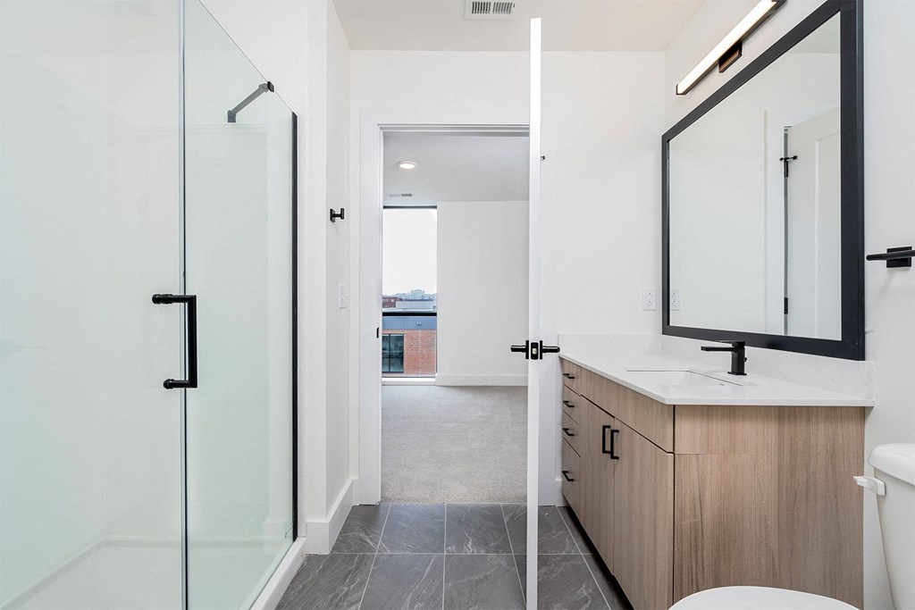 a bathroom with a shower and a sink and a mirror