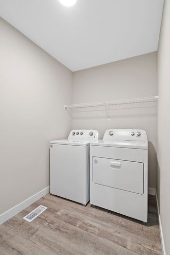 a washer and dryer in a room with a wood floor and white walls