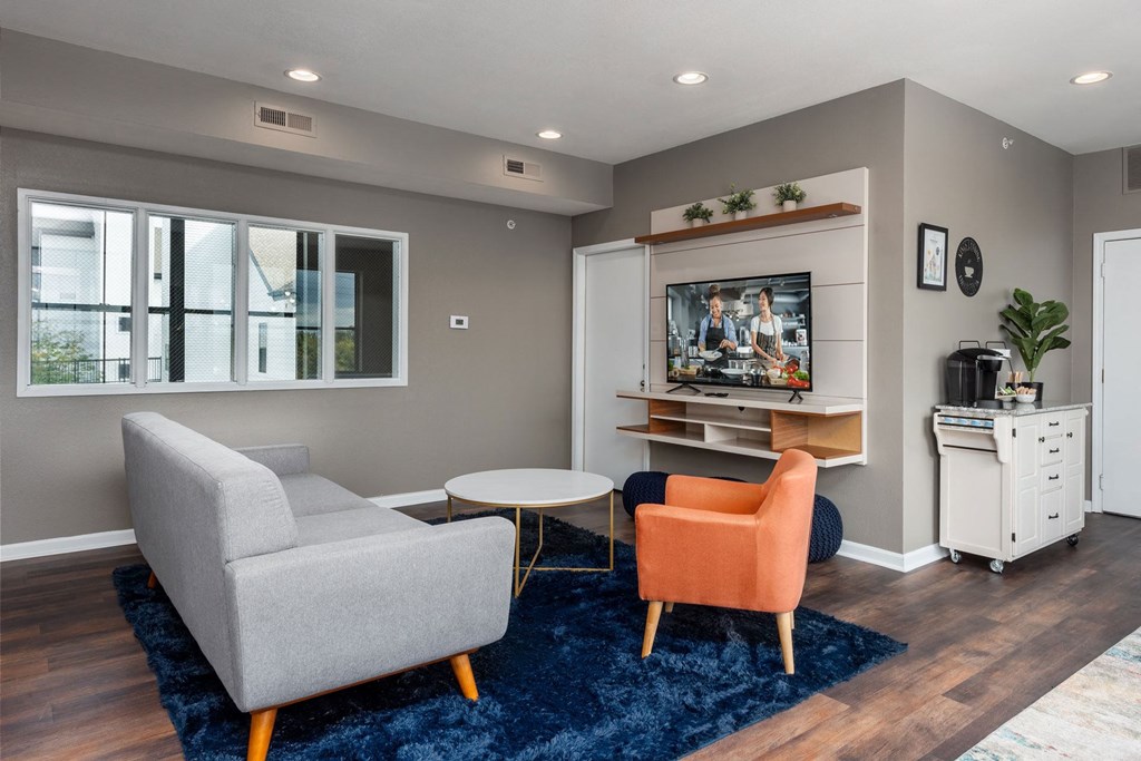 a living room with a couch and two chairs and a television