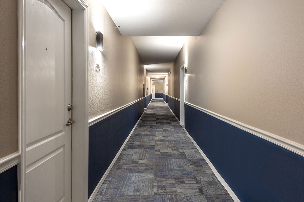 a long hallway with blue and white walls and a wood floor