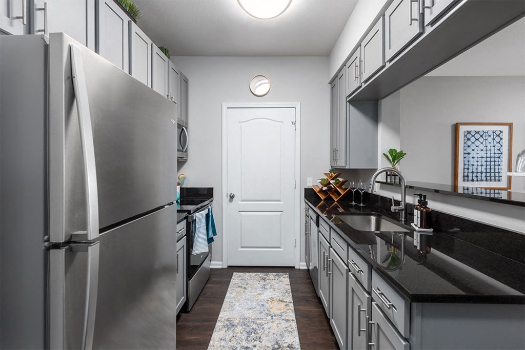 a kitchen with stainless steel appliances and black counter tops